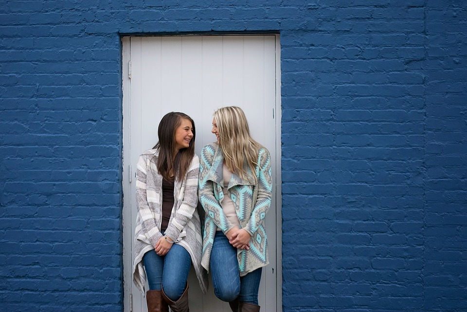 Two girls standing next to each other a smiling
